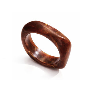 High-resolution close-up of a glossy amber-brown resin bangle with rich marbled swirls in golden and caramel tones, photographed on a clean white background with soft shadows and a polished, high-end finish.