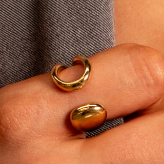 Close-up of the Angelica Open Ring in polished gold, featuring a smooth curved open-band design worn on the finger.