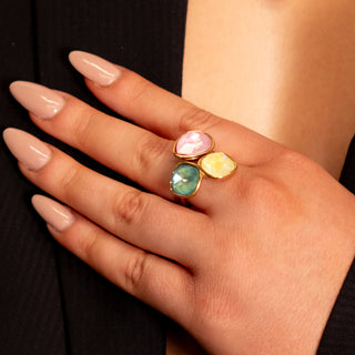 Aurora Prism Ring close-up on hand, featuring three faceted colourful stones in gold for a modern statement look.