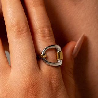 Close-up of the Blair Belt Ring in two-toned gold and silver on a model’s hand, showing its sculptural belt-inspired design.