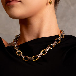 Close-up of the Fifth Avenue Two-Toned Necklace featuring gold and silver interlinked chain links against a black top.