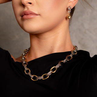 Model wearing the Fifth Avenue Two-Toned Necklace, showcasing its bold gold and silver chain design against a black one-shoulder top.