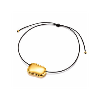 Gold molten pendant necklace on a black adjustable cord, featuring a smooth sculptural shape in a high-shine finish, photographed on a clean white background for Forward & Tame.