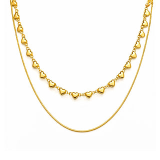 Gold double-layer heart necklace featuring a row of polished heart charms and a sleek gold snake chain. Modern, elegant and luxe, photographed on a clean white background for Forward & Tame.