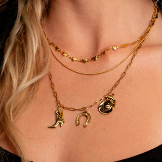 Model wearing the gold heart-link necklace layered with multiple gold chains and Nashville Charm Necklace.