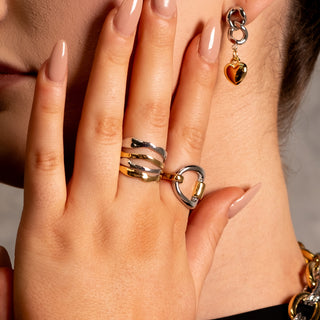 Model wearing the Manhattan Liquid Ring alongside other mixed-metal rings and City Collection earrings, highlighting the ring’s sculptural liquid-metal finish.