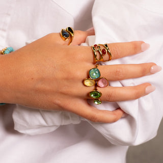 Model wearing the Aurora Prism Ring with colourful gemstones, styled with turquoise bracelets and gold details for a bold Forward & Tame look.
