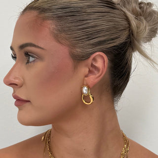 Cara Pearl Twist Hoops 18k gold pearl hoop earrings worn with layered gold necklaces