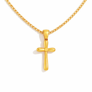 Close-up of a polished gold cross pendant hanging from a thin 18k gold-plated curb chain, photographed against a bright white background. The necklace has a high-shine finish with smooth, tapered detailing for an elevated, luxury look.